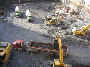 Overhead view of trucks at a mine site, emphasizing proper rigging and towing safety practices to prevent accidents.
