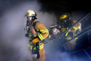 Firefighters in protective gear respond to smoke-filled emergency in underground mine shop.
