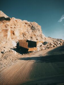 Heavy equipment near highwall demonstrating drainage management for mine safety.
